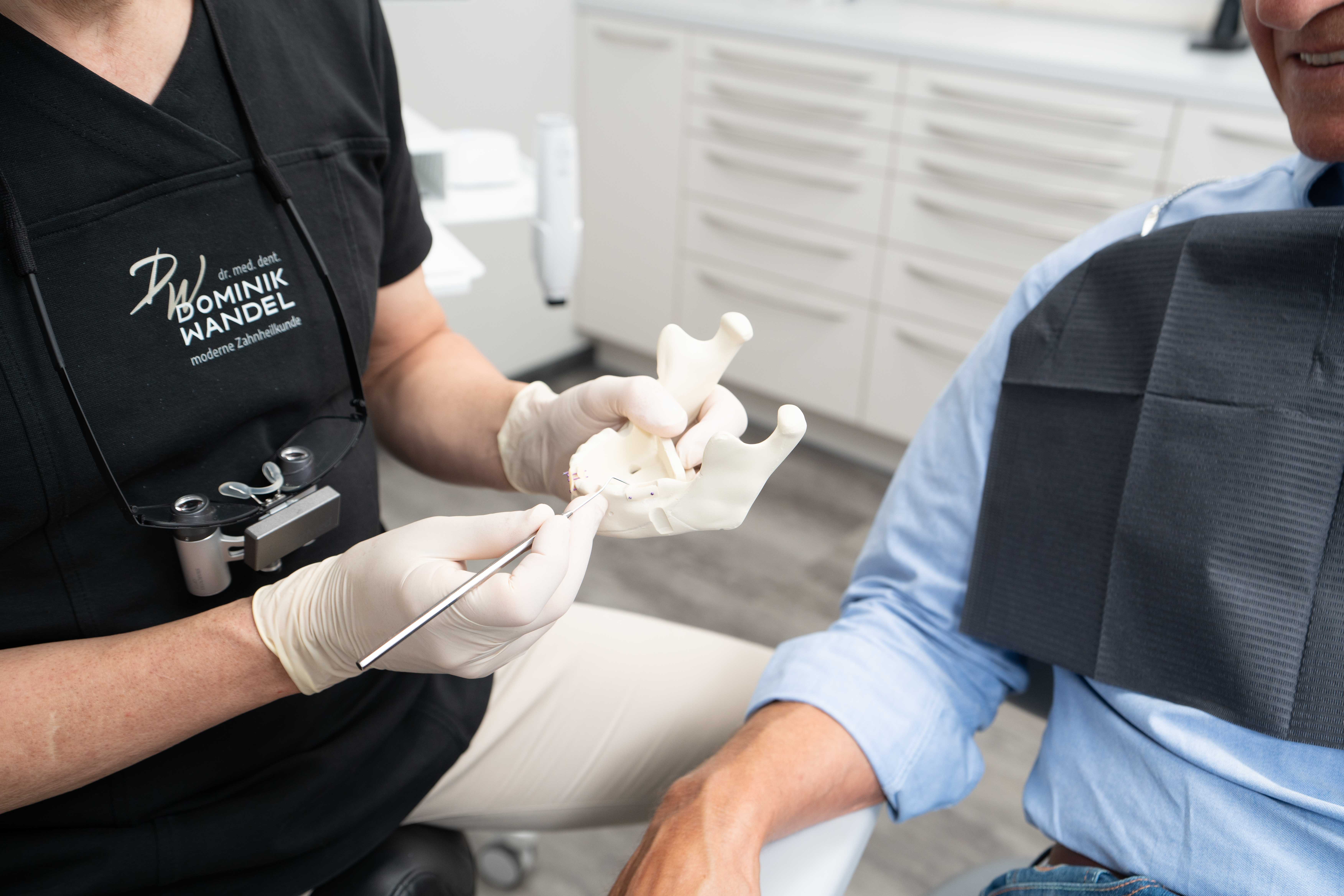 Dr. Dominik Wandel erklärt das Implantat am Kiefer-Modell